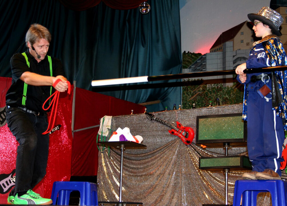 Magier führt Zaubertrick mit Kind vor.